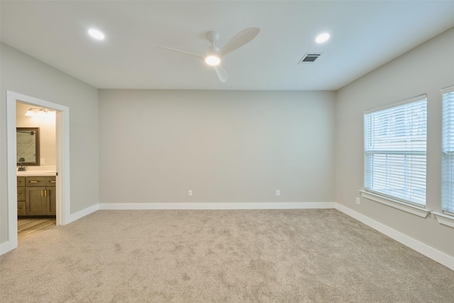 carpeted spare room with ceiling fan