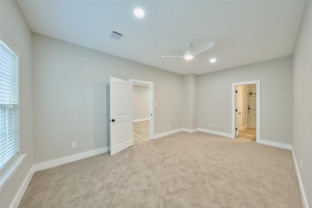 carpeted spare room featuring ceiling fan