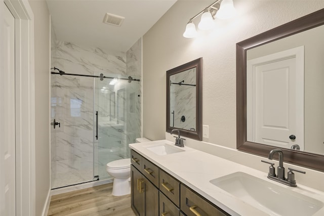 bathroom featuring walk in shower, wood-type flooring, toilet, and vanity