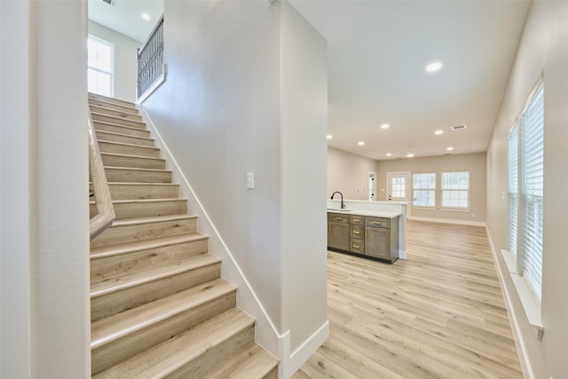 staircase featuring wood-type flooring and sink