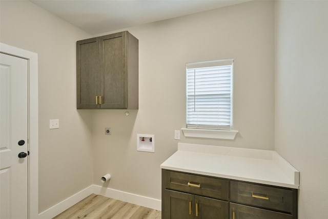 laundry room featuring cabinets, hookup for a washing machine, light hardwood / wood-style floors, and hookup for an electric dryer