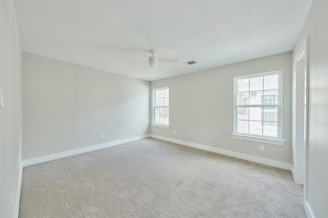 carpeted spare room featuring ceiling fan