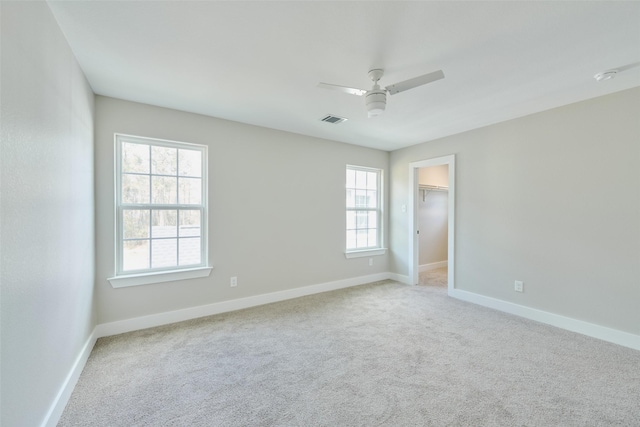 spare room featuring light carpet and ceiling fan