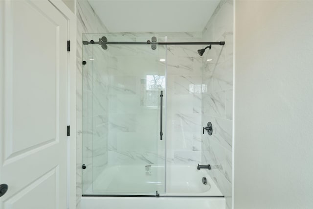 bathroom with bath / shower combo with glass door