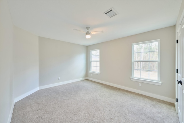 spare room featuring light colored carpet and ceiling fan