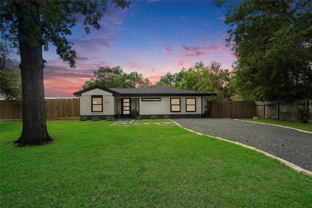 view of front of property featuring fence private yard, a front lawn, and brick siding