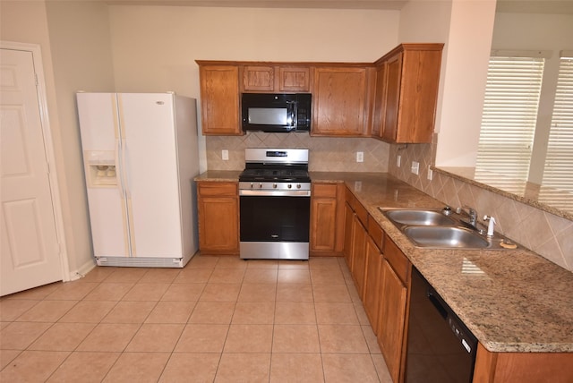 kitchen with tasteful backsplash, sink, light tile patterned floors, and black appliances