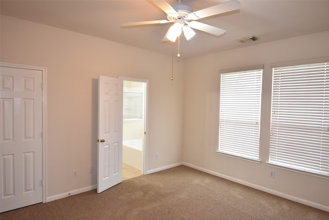 unfurnished bedroom with ceiling fan, light carpet, and ensuite bath