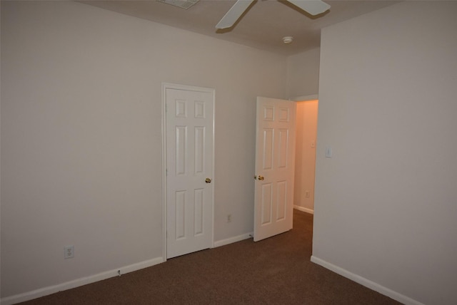 empty room with ceiling fan and dark carpet