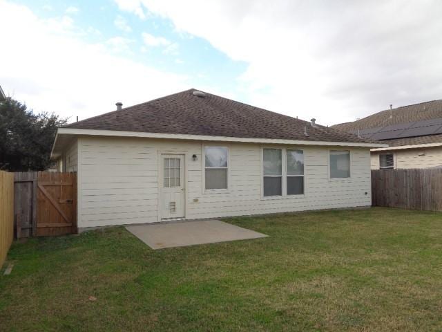 rear view of property with a yard and a patio area