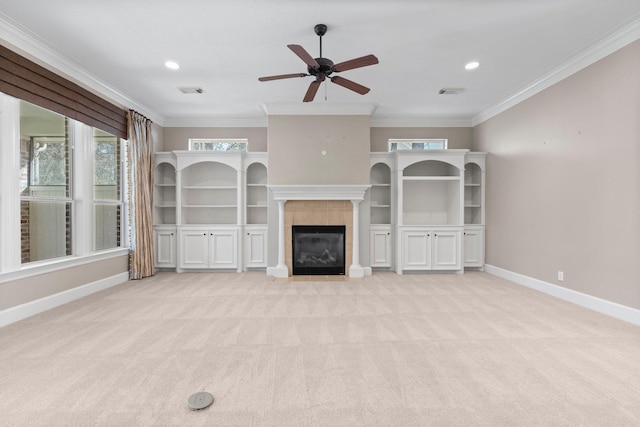 unfurnished living room with light colored carpet, ornamental molding, a tile fireplace, and ceiling fan