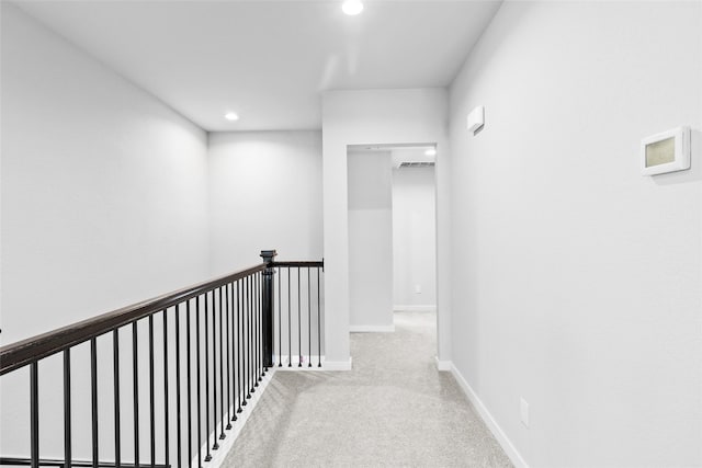 corridor with carpet floors, recessed lighting, visible vents, an upstairs landing, and baseboards