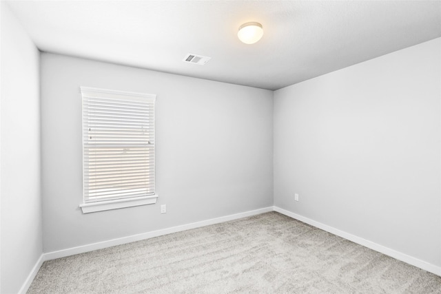 carpeted spare room with baseboards and visible vents