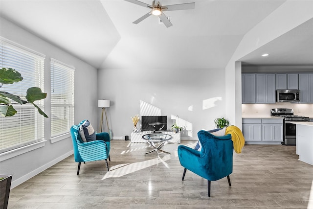 living area with light wood finished floors, baseboards, a ceiling fan, lofted ceiling, and recessed lighting