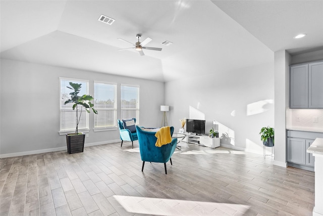 living area with a ceiling fan, baseboards, visible vents, and light wood finished floors