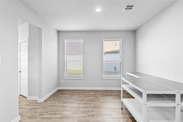 interior space with a wealth of natural light, visible vents, light wood-style flooring, and baseboards