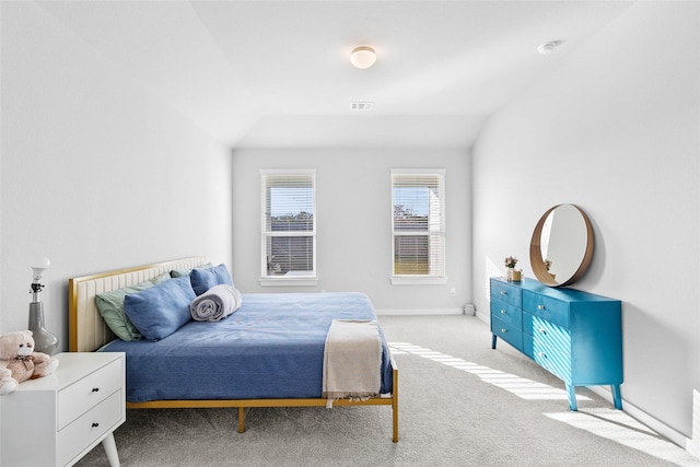 carpeted bedroom with lofted ceiling, baseboards, and visible vents