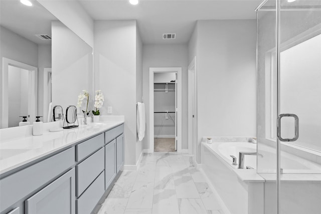 full bath with double vanity, marble finish floor, visible vents, and a walk in closet