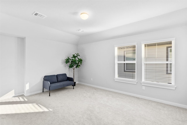 sitting room featuring lofted ceiling, carpet flooring, visible vents, and baseboards