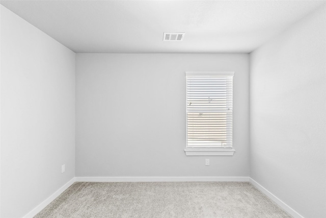 unfurnished room with carpet, visible vents, and baseboards