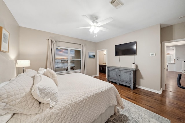 bedroom featuring visible vents, wood finished floors, connected bathroom, baseboards, and ceiling fan