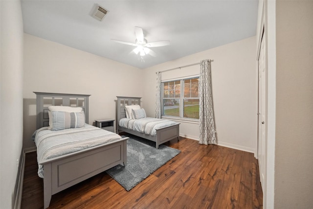 bedroom with visible vents, baseboards, a ceiling fan, and wood finished floors