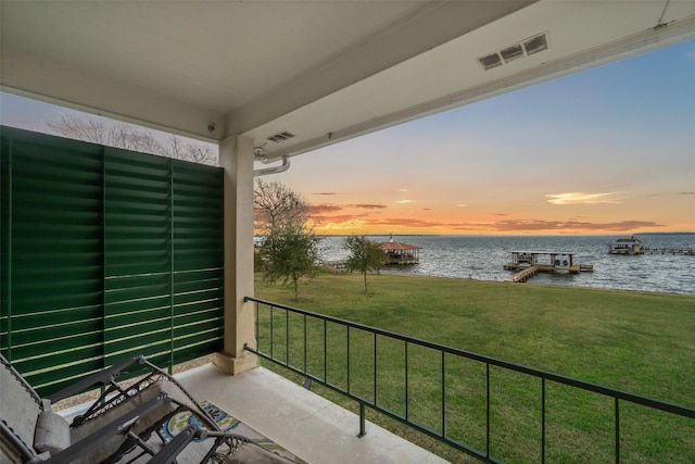 balcony featuring visible vents, a water view, and a dock