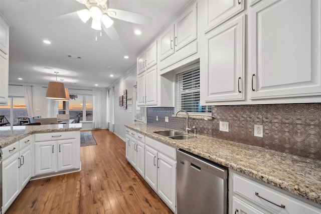kitchen featuring stainless steel dishwasher, white cabinetry, and a sink