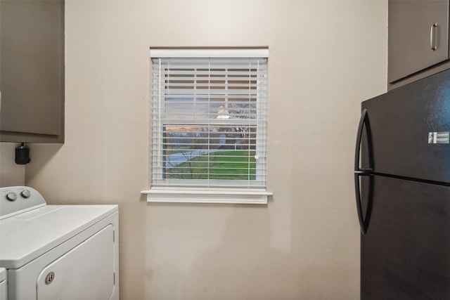 clothes washing area featuring cabinet space and washing machine and clothes dryer
