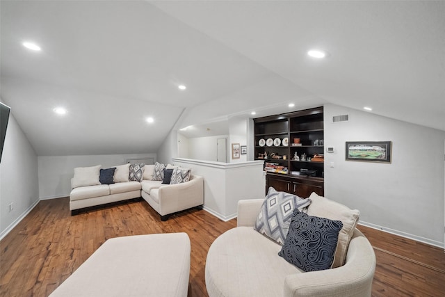 living area featuring recessed lighting, baseboards, lofted ceiling, and wood finished floors