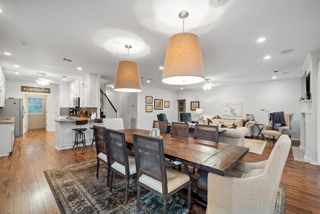 dining area with ceiling fan, visible vents, light wood finished floors, and ornamental molding