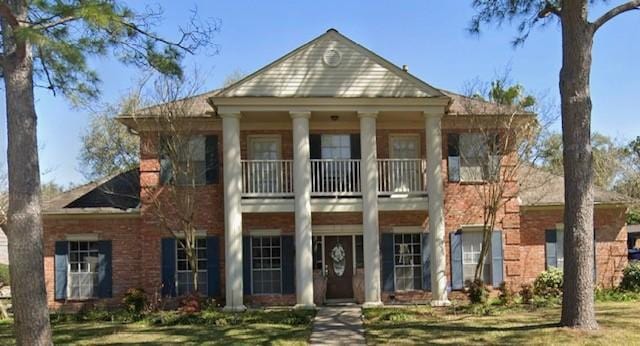 greek revival inspired property featuring a balcony