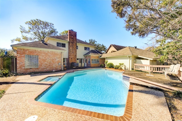 view of swimming pool with a pool with connected hot tub and a wooden deck