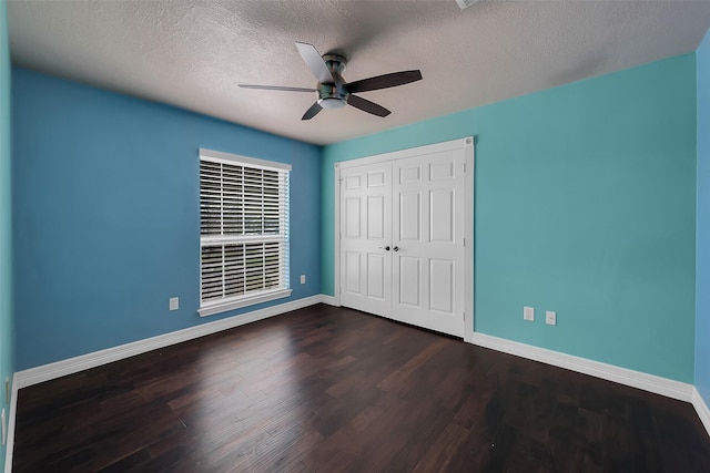 unfurnished bedroom featuring dark hardwood / wood-style flooring, ceiling fan, a closet, and a textured ceiling