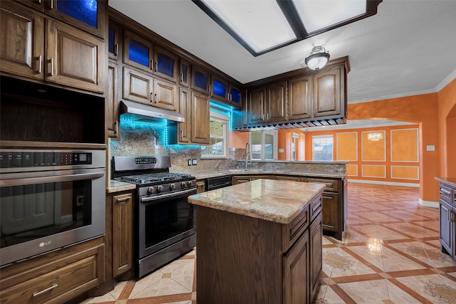 kitchen with tasteful backsplash, sink, a center island, crown molding, and stainless steel range with gas stovetop