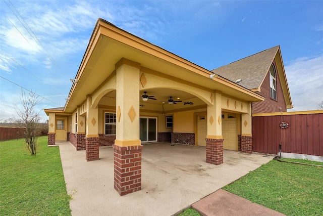 back of property with ceiling fan, a yard, a patio, and a garage