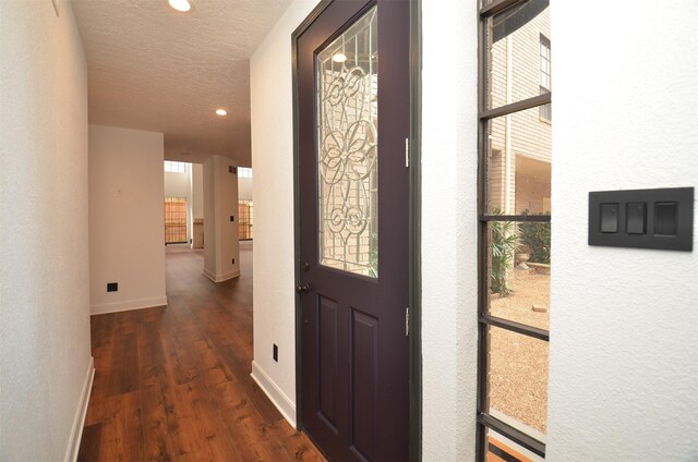 foyer entrance featuring a textured ceiling and dark hardwood / wood-style flooring