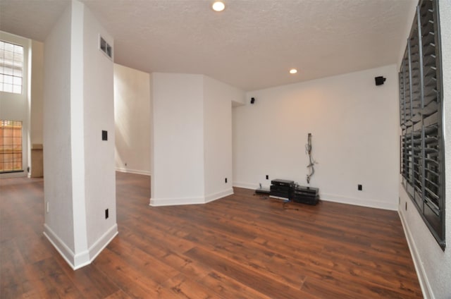 unfurnished living room with visible vents, baseboards, recessed lighting, wood finished floors, and a textured ceiling