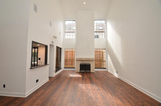 unfurnished living room featuring a fireplace, baseboards, and wood finished floors