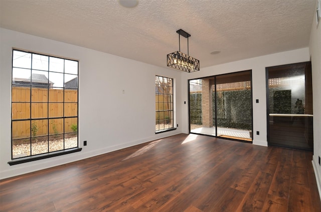 unfurnished dining area featuring dark hardwood / wood-style flooring and a textured ceiling