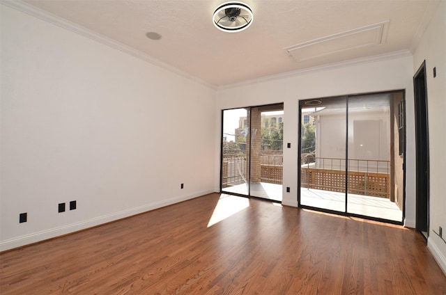 unfurnished room with crown molding, baseboards, and wood finished floors