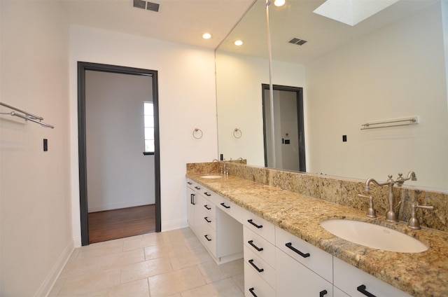 full bathroom with a sink, visible vents, a skylight, and double vanity