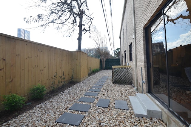 exterior space featuring brick siding and a fenced backyard