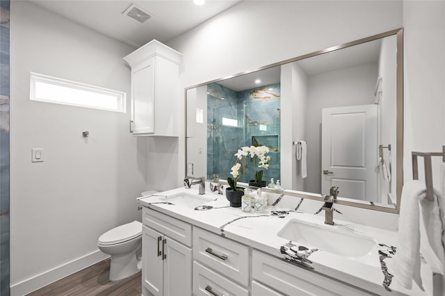 bathroom with wood-type flooring, vanity, an enclosed shower, and toilet