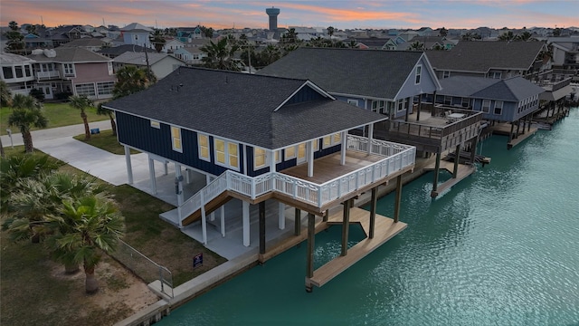 aerial view at dusk featuring a water view