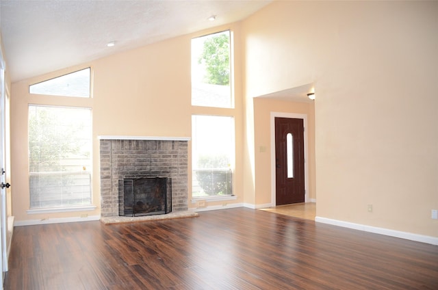 unfurnished living room featuring wood-type flooring, high vaulted ceiling, and a fireplace