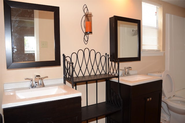 bathroom with a healthy amount of sunlight, vanity, and toilet