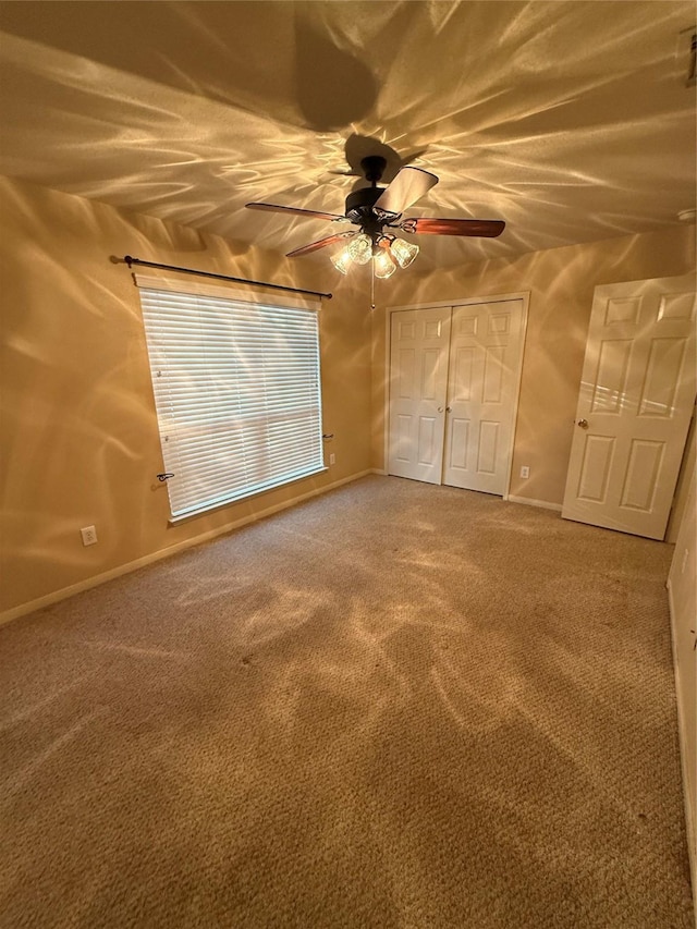 unfurnished bedroom featuring a closet, ceiling fan, and carpet