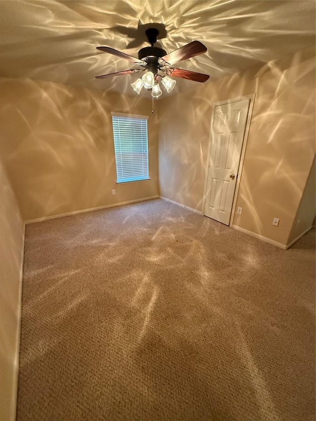 unfurnished room with ceiling fan and carpet