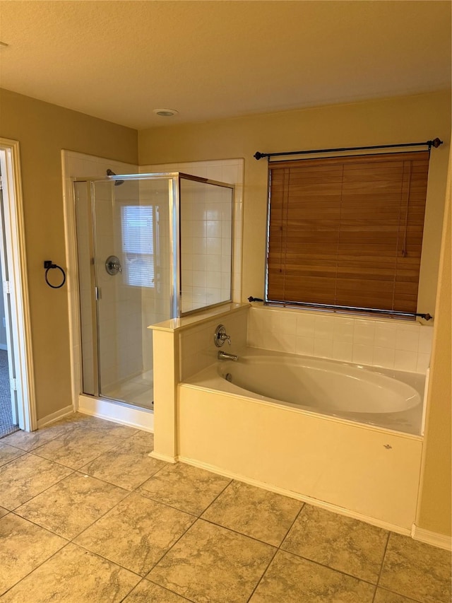 bathroom with tile patterned flooring and separate shower and tub